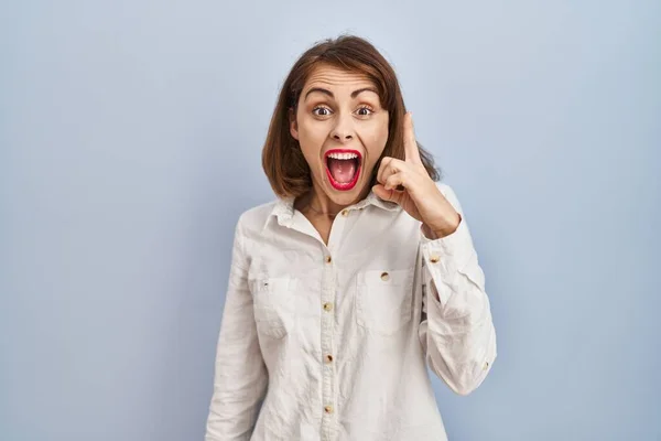 Junge Schöne Frau Steht Lässig Vor Blauem Hintergrund Und Zeigt — Stockfoto