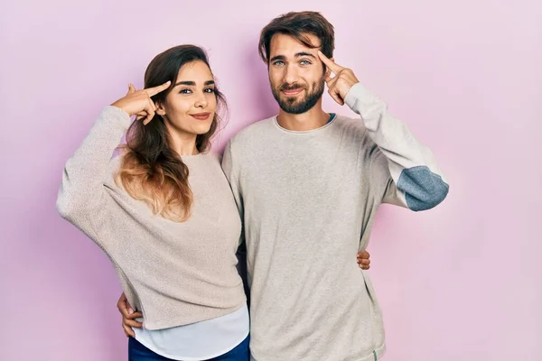 若いヒスパニック系のカップルは 1本の指で頭を指して笑みを浮かべてカジュアルな服を着て 素晴らしいアイデアや考え 良い記憶 — ストック写真