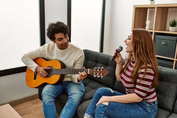 Casal Jovem Tocando Guitarra Clássica Cantando Usando Microfone Casa — Fotografia de Stock