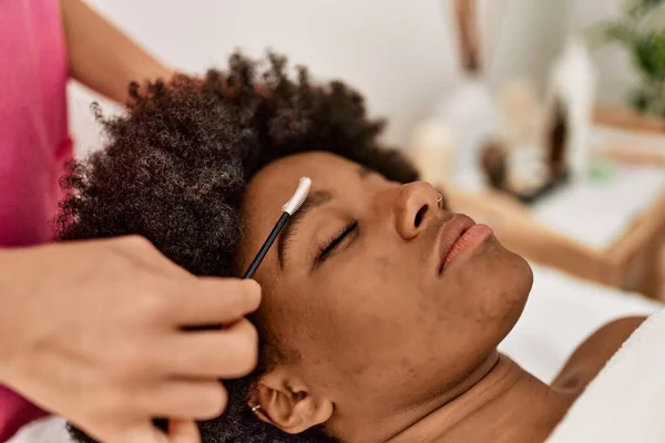 在美容中心接受眼部治疗的年轻非洲裔美国妇女 — 图库照片