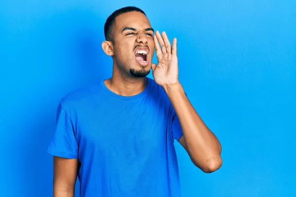 年轻的非洲裔美国人 身穿休闲蓝T恤 大喊大叫 手拉手捂住嘴 传播概念 — 图库照片