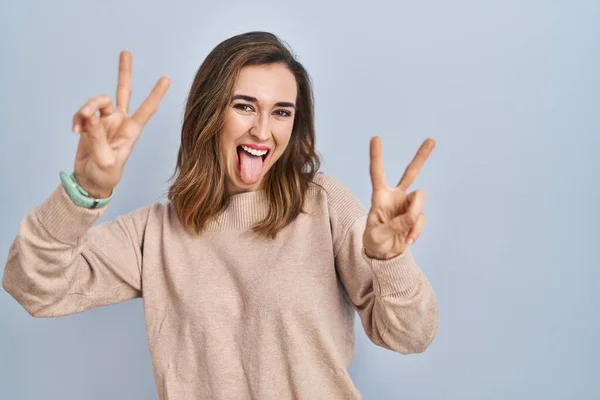 Young Woman Standing Isolated Background Smiling Tongue Out Showing Fingers — Stockfoto