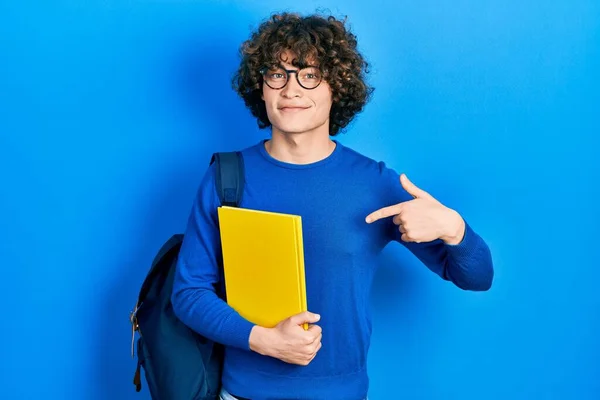 Красивый Молодой Человек Студенческом Рюкзаке Книгой Руках Указывая Пальцем Себя — стоковое фото