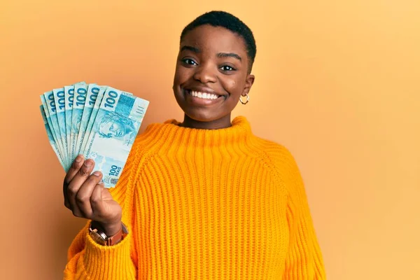 Mladá Africká Americká Žena Drží 100 Brazilských Reálných Bankovek Vypadá — Stock fotografie