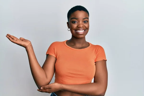 Joven Mujer Afroamericana Vistiendo Camiseta Naranja Casual Sonriendo Alegre Presentando —  Fotos de Stock