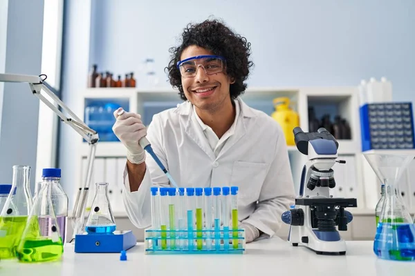 Young Hispanic Man Wearing Scientist Uniform Using Pipette Laboratory — Fotografia de Stock