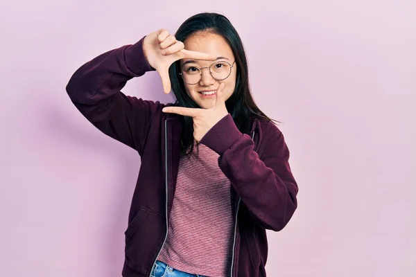 Молодая Китайская Девушка Повседневной Одежде Очках Улыбается Делая Рамку Руками — стоковое фото