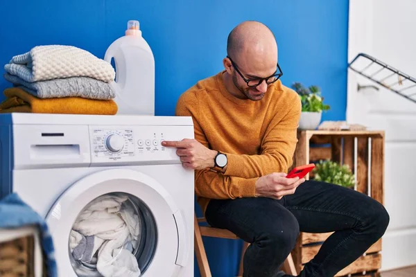 Ung Man Med Smartphone Slå Tvättmaskin Tvättstugan — Stockfoto