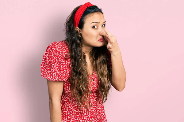 若いヒスパニック系の女の子は 鼻の上に指で息を保持し 何か臭いと嫌な 耐え難い匂いを嗅ぐカジュアルな服を着て 臭いが悪い — ストック写真