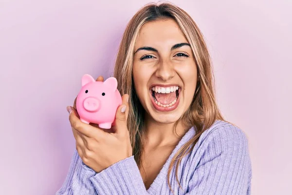 Mooie Latino Vrouw Holding Piggy Bank Vieren Gek Verbaasd Voor — Stockfoto