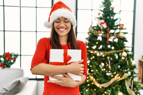 Jovem Mulher Latina Abraçando Presente Pela Árvore Natal Casa — Fotografia de Stock