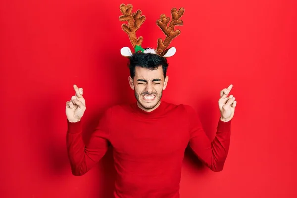 Mladý Hispánec Oblečený Roztomilých Vánočních Rohů Soby Ukazoval Prstem Přes — Stock fotografie