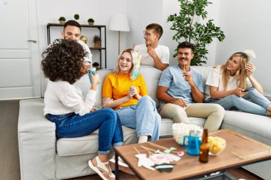 Bir grup genç arkadaş evde komik kostümlü aksesuarlar giyip parti veriyor..