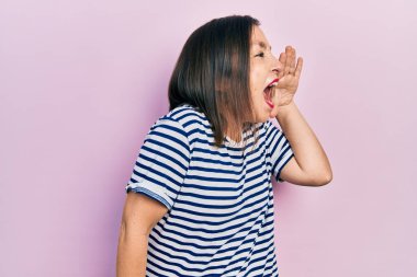 Orta yaşlı İspanyol kadın gündelik kıyafetler giyip el ele verip bağırıyor. iletişim konsepti. 