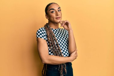 Makyajlı, uzun saçlı, modern kıyafetler giyen, kameraya gülümseyen kolları çapraz ve çenesi açık bakan İspanyol bir adam. Olumlu düşünmek. 