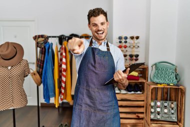 Perakende mağazasının müdürü olarak çalışan yakışıklı genç adam seni ve kamerayı parmaklarıyla göstererek mutlu ve mutlu bir şekilde gülümsüyor. 