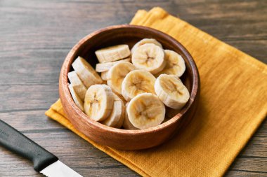 Tahta bir masada muz dilimlerinin fotoğrafı.