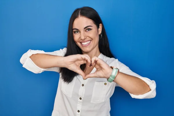 Mujer Hispana Joven Pie Sobre Fondo Azul Sonriendo Amor Haciendo —  Fotos de Stock