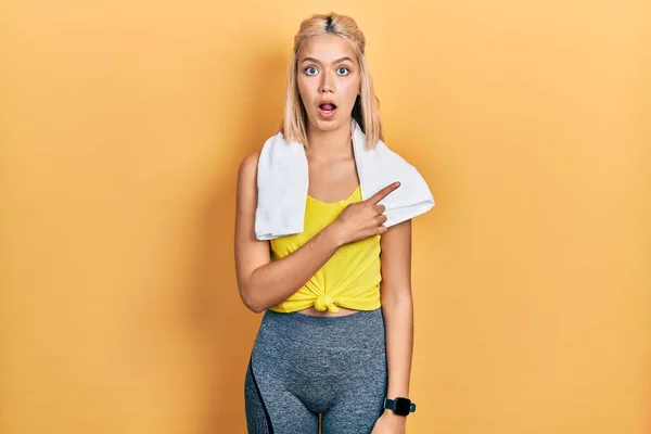 Beautiful Blonde Sports Woman Wearing Workout Outfit Surprised Pointing Finger — Stockfoto