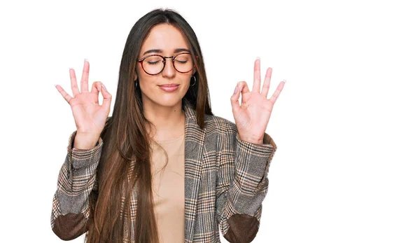 穿着商务服装和眼镜的年轻惊慌失措的女孩放松了下来 闭上了眼睛 用手指做冥想动作 瑜伽概念 — 图库照片