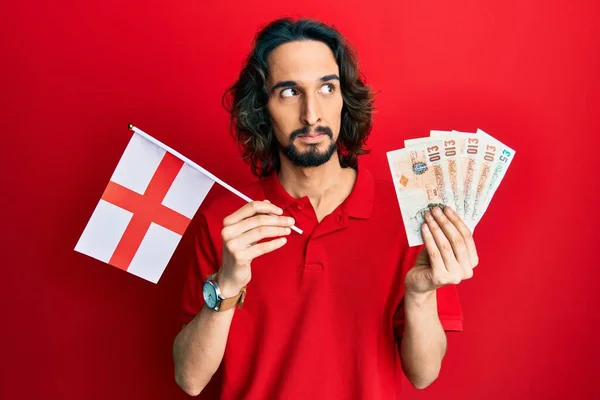 Joven Hispano Sosteniendo Bandera Inglaterra Libras Billetes Sonriendo Mirando Costado —  Fotos de Stock