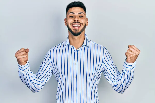 Mladý Hispánec Vousy Neformální Pruhované Košili Oslavující Překvapení Úžas Nad — Stock fotografie
