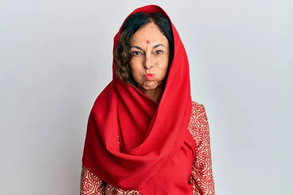 中世のヒスパニック系の女性は 伝統的なSherwaniを着て面白い顔で頬をむいて服を見た 口は空気で膨らみ狂気の表情で — ストック写真