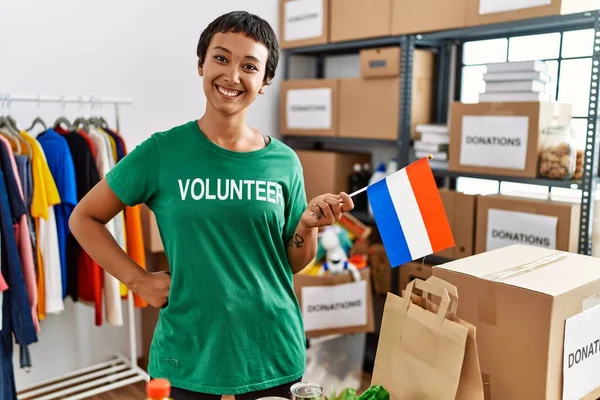 Yardım Merkezinde Hollanda Bayrağı Taşıyan Gönüllü Üniformalı Genç Spanyol Kadın — Stok fotoğraf