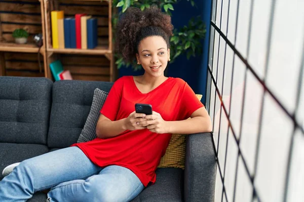 Ung Afrikansk Amerikansk Kvinna Med Smartphone Sitter Soffan Hemma — Stockfoto