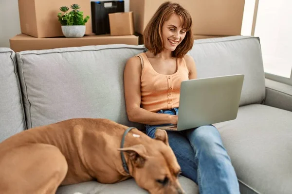 Jovem Caucasiana Usando Laptop Sentado Sofá Com Cão Casa — Fotografia de Stock
