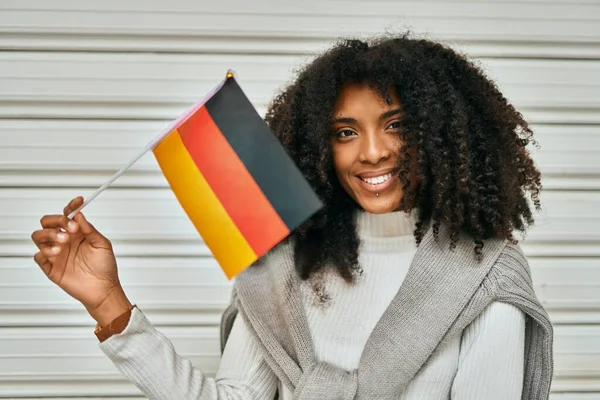 Joven Mujer Afroamericana Sonriendo Feliz Sosteniendo Bandera Alemania Ciudad —  Fotos de Stock