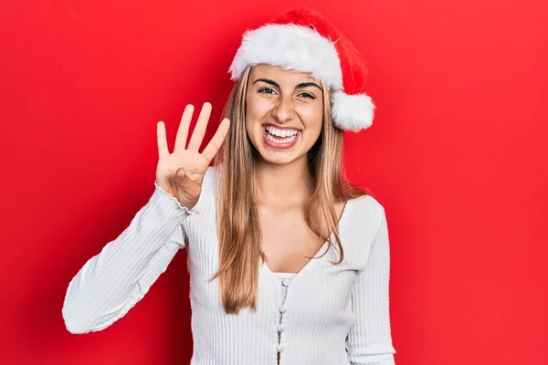 他那戴着圣诞礼帽的美丽的惊慌失措的女人 带着自信和快乐的笑容 用第四指了指 — 图库照片