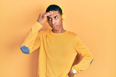 Kulaklıkla müzik dinleyen Afro-Amerikalı genç adam. Alnındaki sorun yüzünden endişeli ve stresli. Kriz için endişeli. 