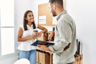 İki Latin iş adamı panoya yazı yazıp ofiste kahve içiyorlar..