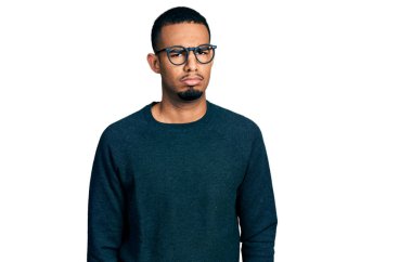 Gündelik kıyafetler giyen, gözlüklü, şüpheci ve gergin genç Afro-Amerikalı bir adam sorun yüzünden üzgün. negatif kişi. 