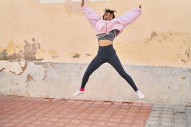 Sokakta atlarken kendine güvenen genç bir kadın.