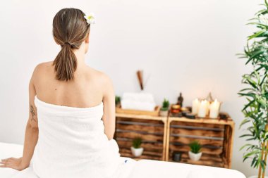 Arkadaki İspanyol kadın güzellik merkezindeki masaj masasında oturuyor..