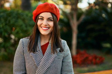 Genç İspanyol kadın gülümseyerek şehirde mutlu mesut dikiliyor..