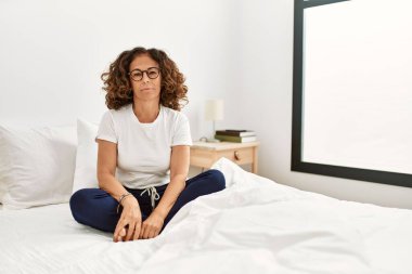 Orta yaşlı İspanyol bir kadın evde yatakta oturuyor ve yüzünde ciddi bir ifadeyle rahatlıyor. Basit ve doğal bir şekilde kameraya bakıyorsun.. 