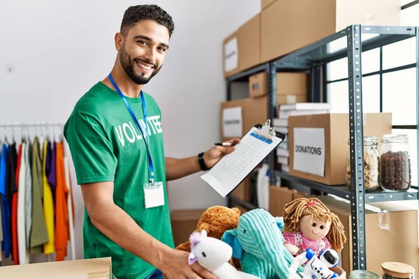 Gönüllü üniformalı genç bir Arap hayır kurumunda çalışıyor.