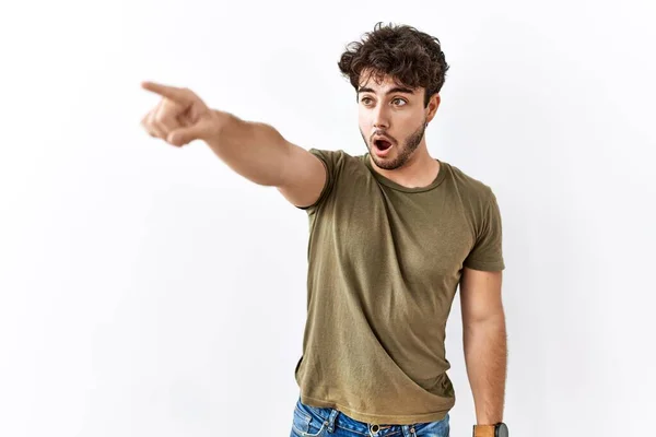 Hispanic Man Standing Isolated White Background Pointing Finger Surprised Ahead — ストック写真