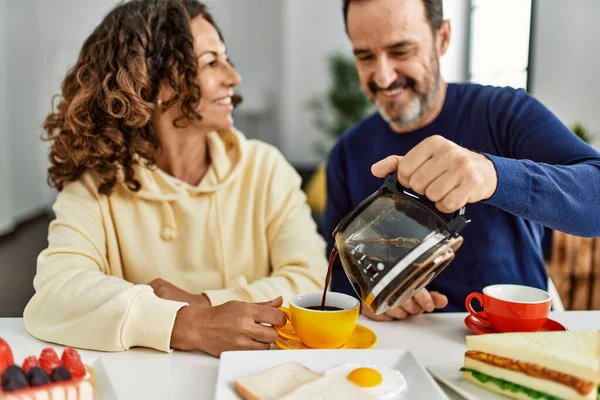 Pareja Hispana Mediana Edad Sonriendo Feliz Sentada Mesa Desayunando Casa —  Fotos de Stock