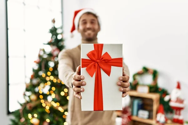 Giovane Uomo Ispanico Sorridente Fiducioso Tenendo Regalo Natale Casa — Foto Stock