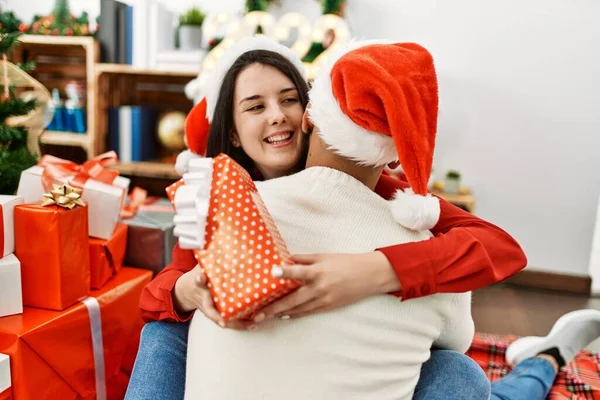 남녀는 행복하게 껴안고 있습니다 집에서 선물을 크리스마스 모자를 마루에 — 스톡 사진