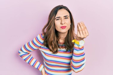 Gündelik kıyafetler giyen genç İspanyol kız İtalyan jesti yapıyor, elleri ve parmakları ile kendinden emin ifade ediyor. 