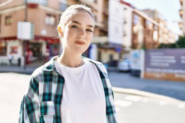 Modern beyaz saç stili ile genç ve güzel bir kadın dışarıda mutlu bir şekilde gülümsüyor.