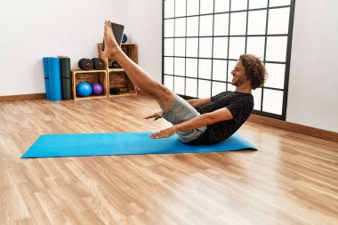 Genç İspanyol sporcu gülümseyerek spor merkezinde mutlu bir antrenman yapıyor..