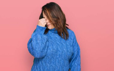 Genç ve cüsseli kadınlar günlük kıyafetler giyip yorgun burunlarını ve gözlerini ovuşturup yorgunluk ve baş ağrısı çekiyor. Stres ve hüsran kavramı. 