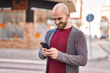 Sokakta akıllı telefon kullanan kendine güvenen genç adam.