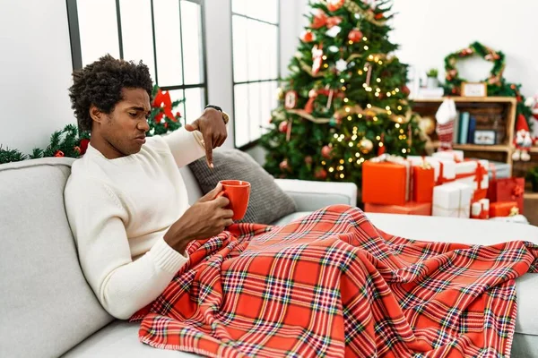 Joven Hombre Afroamericano Sentado Sofá Bebiendo Café Por Árbol Navidad — Foto de Stock